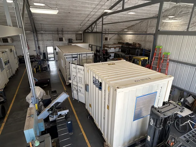 Reinforced flooring in a generator housing container for heavy equipment