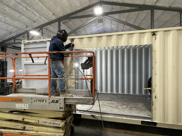 Container modification detail — lock bar and hinge reinforcement