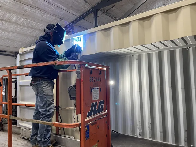 Modified container with custom steel awning and signage bracket