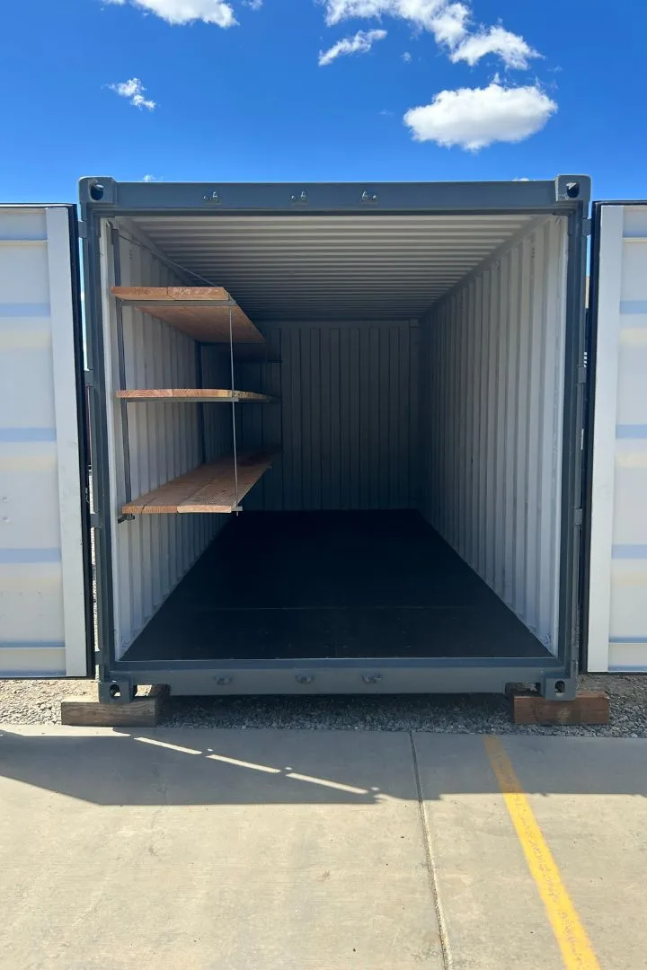 Container with doors open showing three-tier wood shelving system installed along the left wall